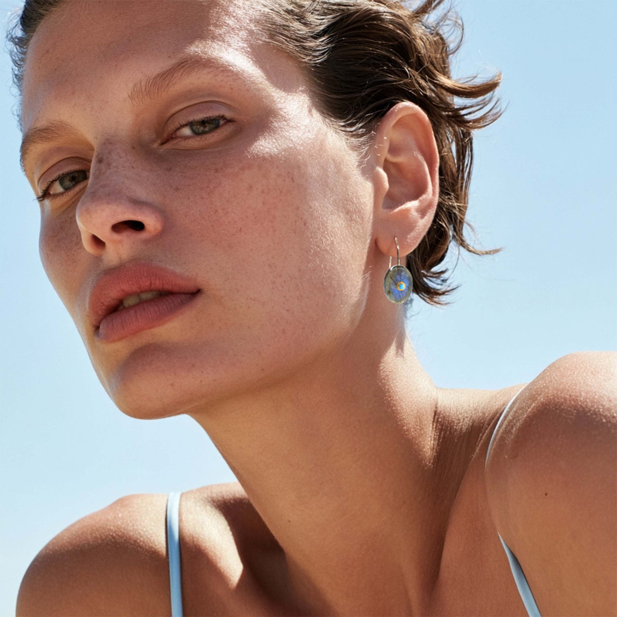 Model wearing Bombyx House drop earrings in 14K gold